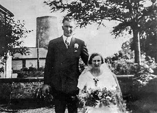 Wedding photo with truncated mill tower behind - c.1930